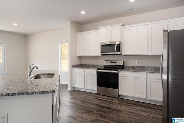 kitchen featuring sink, an island with sink, white cabinets, and appliances with stainless steel finishes