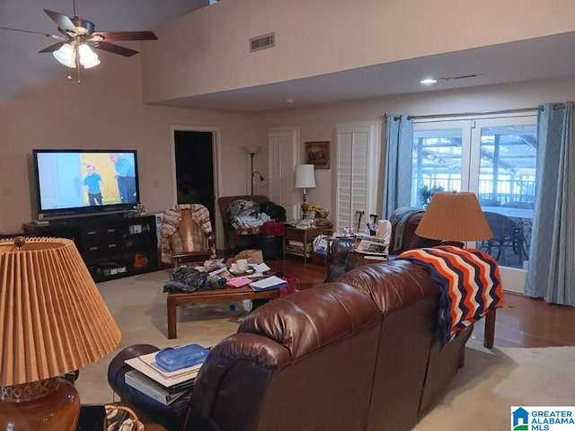 living room featuring ceiling fan and a high ceiling