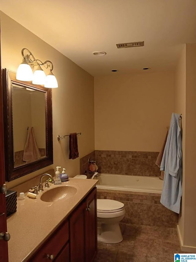 bathroom featuring vanity, a relaxing tiled tub, and toilet