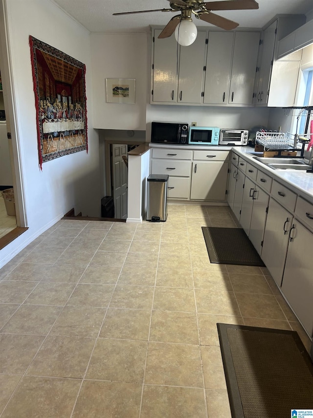 kitchen with light tile patterned flooring, ceiling fan, and sink