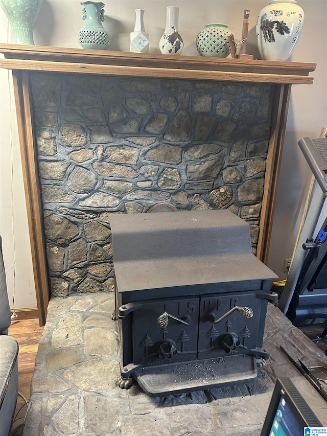 room details with a wood stove and hardwood / wood-style floors