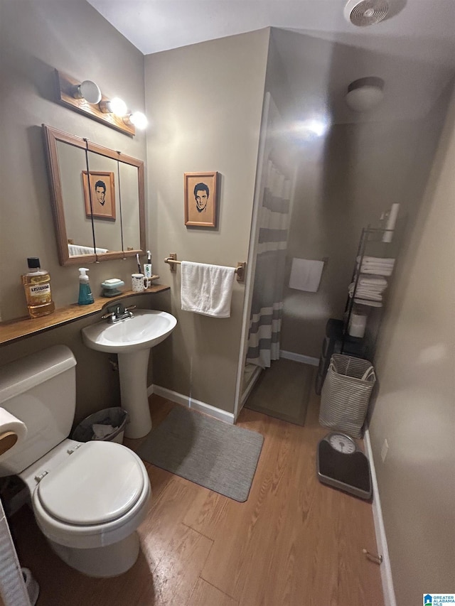 bathroom featuring hardwood / wood-style flooring and toilet