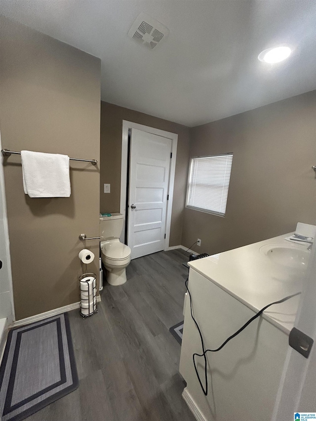 bathroom with hardwood / wood-style flooring, toilet, and sink