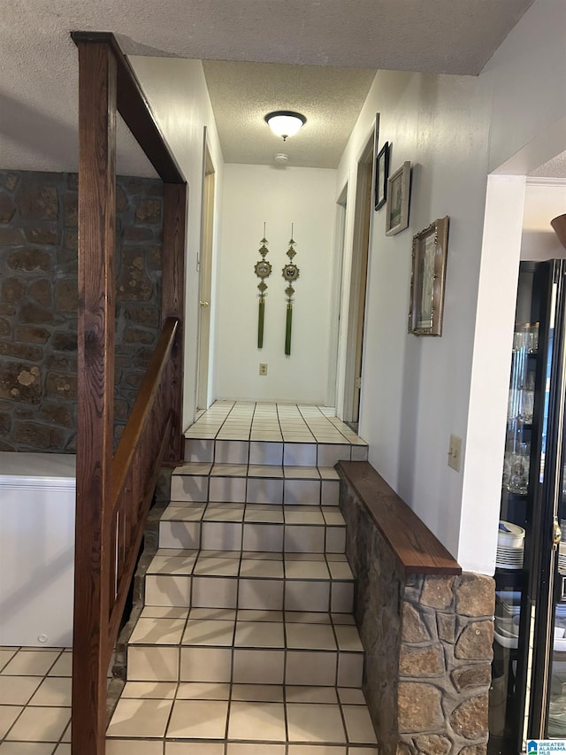 staircase with tile patterned flooring and a textured ceiling