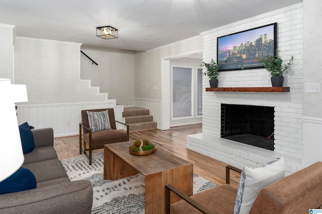 living room featuring ornamental molding, hardwood / wood-style floors, and a fireplace