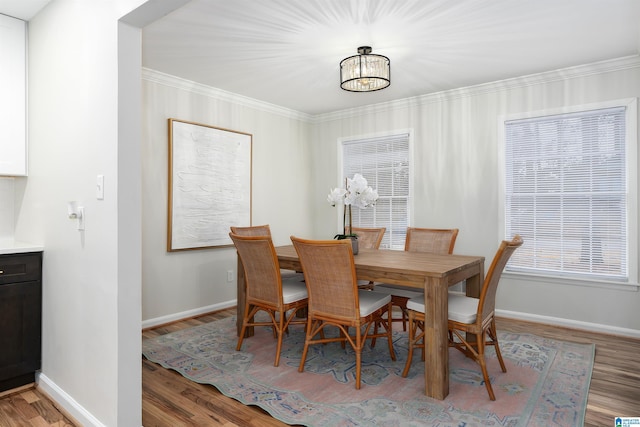 dining room with crown molding, an inviting chandelier, and light hardwood / wood-style floors