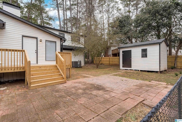 view of patio with a wooden deck, central AC, and a storage shed