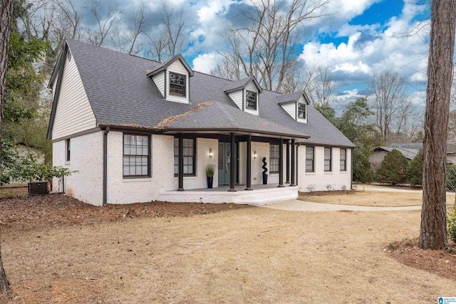 new england style home featuring a porch and central air condition unit