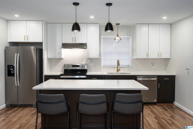 kitchen featuring sink, white cabinetry, a center island, stainless steel appliances, and hardwood / wood-style floors