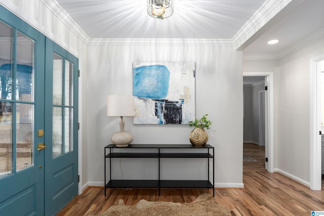 entryway with crown molding, hardwood / wood-style floors, and a notable chandelier