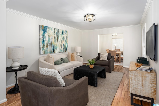 living room featuring ornamental molding and light hardwood / wood-style flooring