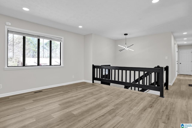 spare room with light wood-type flooring, visible vents, baseboards, and recessed lighting