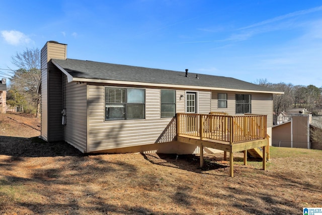 back of property featuring a shingled roof, a chimney, and a wooden deck