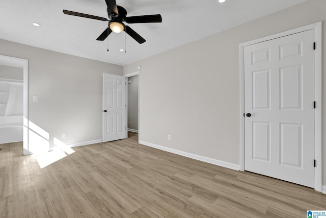 unfurnished bedroom featuring ceiling fan, light wood finished floors, and baseboards