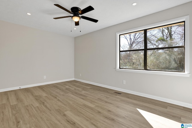 empty room with recessed lighting, light wood-type flooring, visible vents, and baseboards