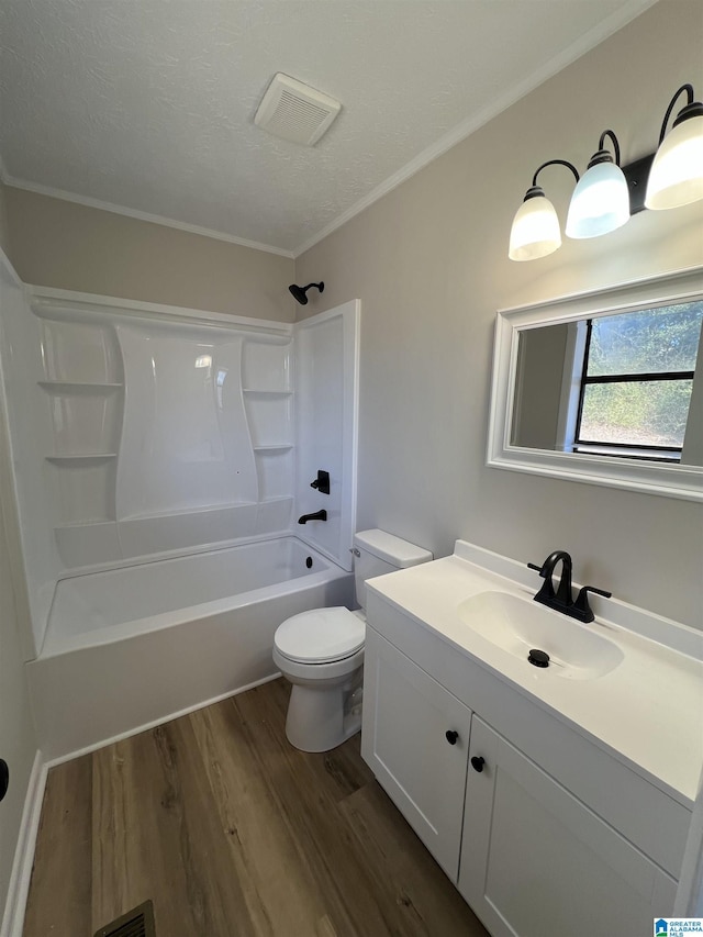 bathroom featuring visible vents, toilet, tub / shower combination, vanity, and wood finished floors