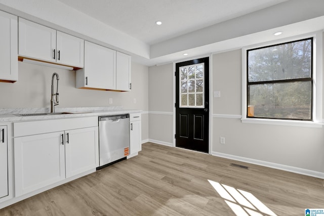 kitchen featuring a sink, light wood finished floors, white cabinetry, and stainless steel dishwasher