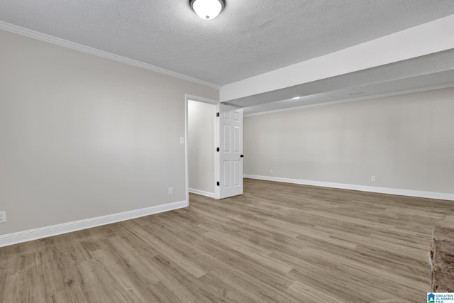 unfurnished room with a textured ceiling, wood finished floors, and baseboards