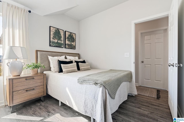 bedroom featuring vaulted ceiling and dark wood-style flooring