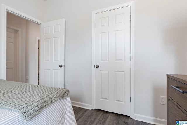 bedroom with dark wood-style floors and baseboards