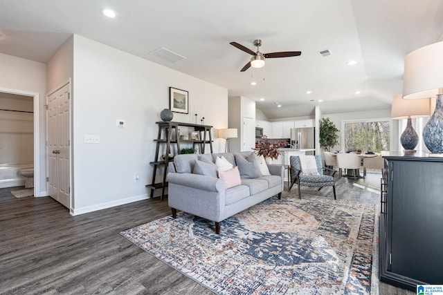 living area with baseboards, visible vents, dark wood-style flooring, and recessed lighting