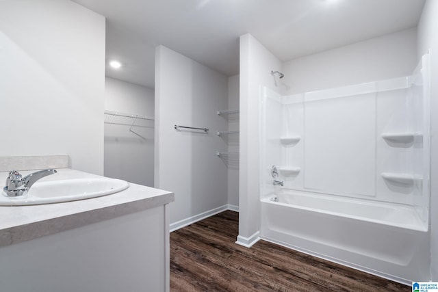 bathroom with hardwood / wood-style flooring, vanity, and bathing tub / shower combination