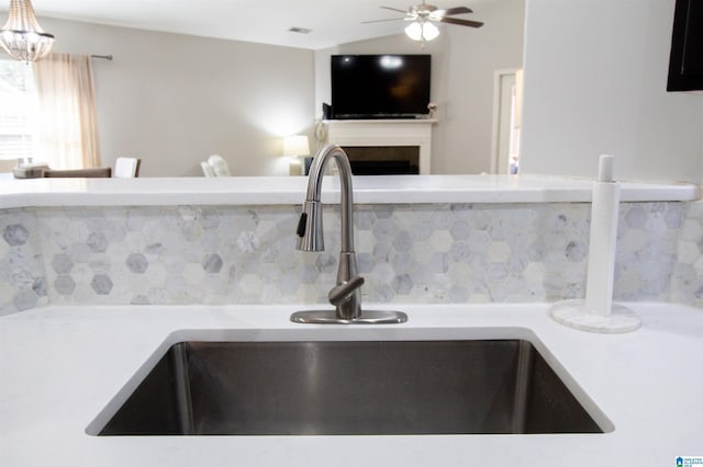 interior details with sink, backsplash, and ceiling fan