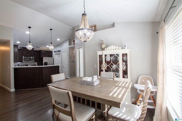 dining area with lofted ceiling, dark hardwood / wood-style floors, and a chandelier