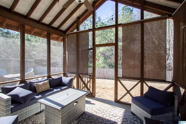 unfurnished sunroom featuring vaulted ceiling with beams