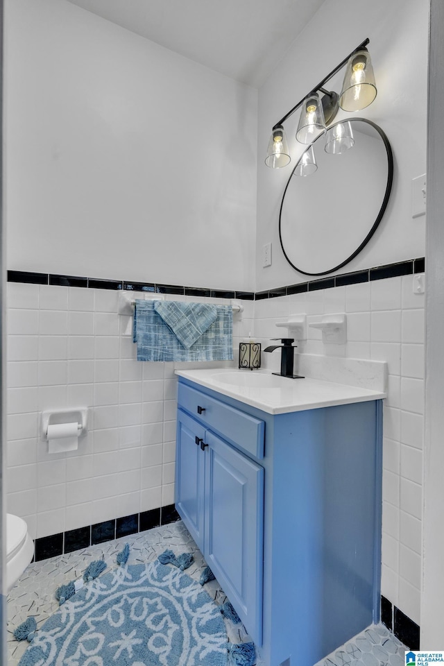 bathroom featuring vanity, tile walls, tile patterned floors, and toilet