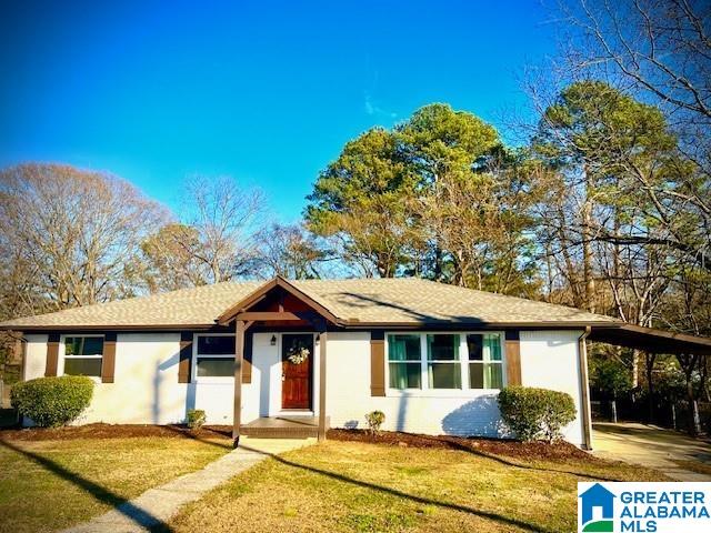 single story home featuring a carport and a front lawn