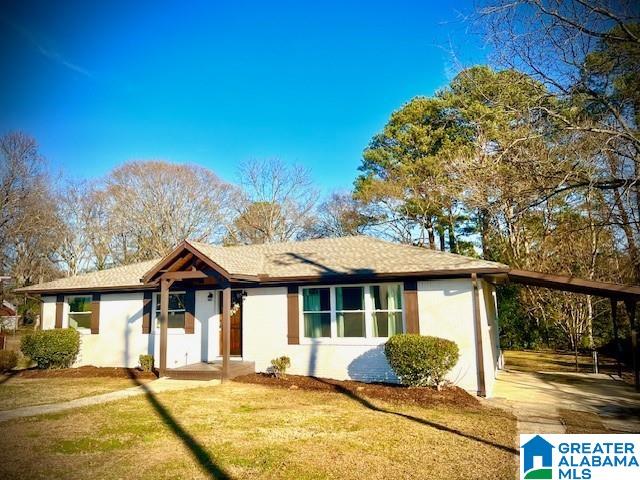 view of front of house featuring a carport and a front lawn