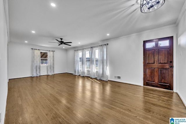 foyer entrance with hardwood / wood-style flooring, ornamental molding, and ceiling fan