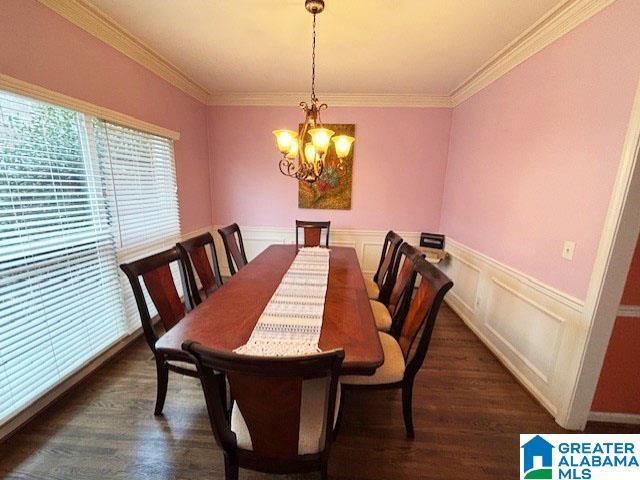 dining space with crown molding, dark hardwood / wood-style floors, and a chandelier