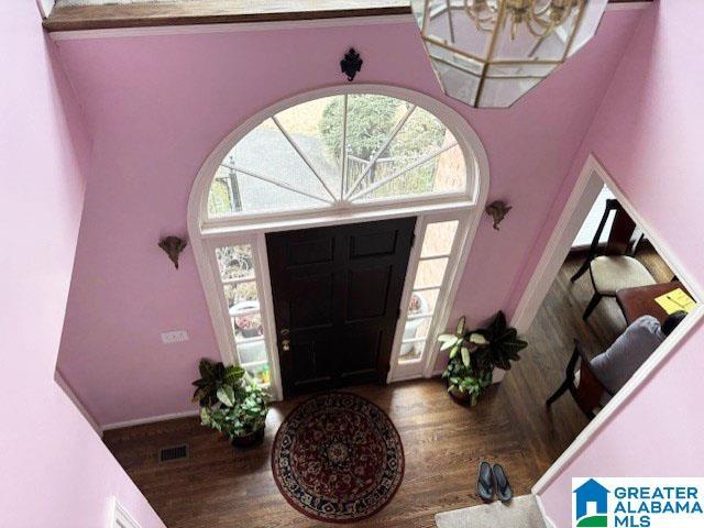 foyer with hardwood / wood-style flooring and a chandelier