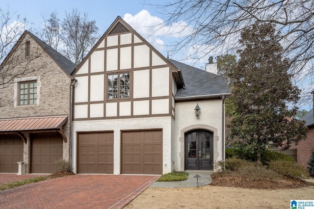 english style home with french doors and a garage