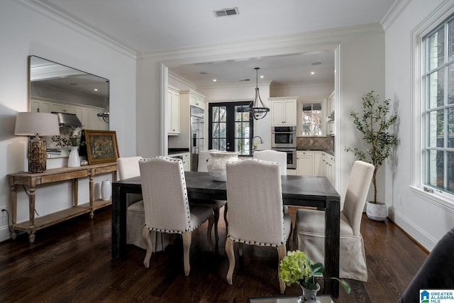 dining area with ornamental molding, a healthy amount of sunlight, dark hardwood / wood-style flooring, and french doors