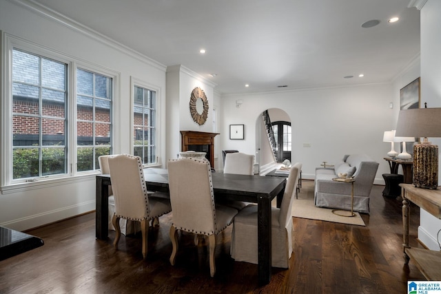 dining area with crown molding, a healthy amount of sunlight, and dark hardwood / wood-style floors