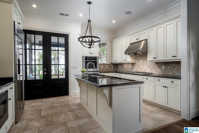 kitchen with a kitchen island with sink, hanging light fixtures, white cabinetry, and appliances with stainless steel finishes