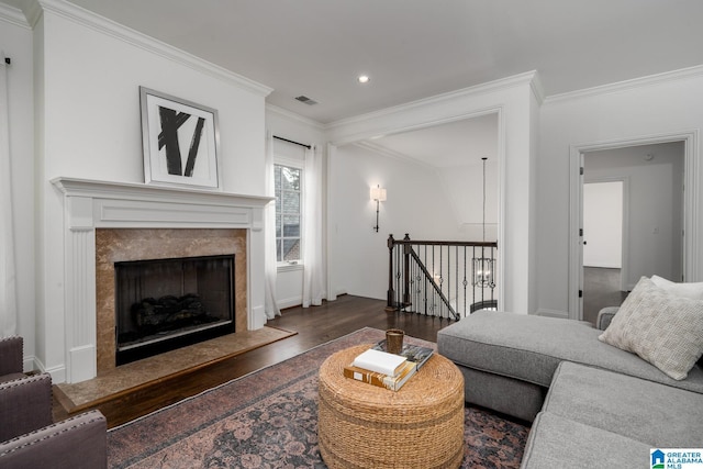 living room featuring a premium fireplace, ornamental molding, and dark hardwood / wood-style floors