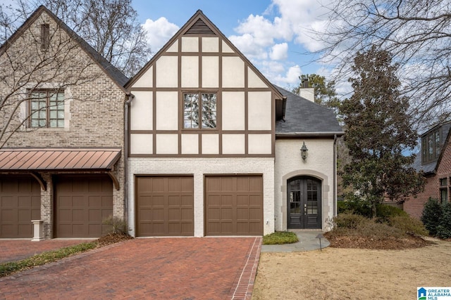 tudor house featuring a garage and french doors