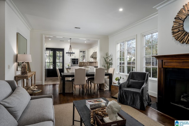 living room featuring a healthy amount of sunlight, dark hardwood / wood-style floors, and ornamental molding