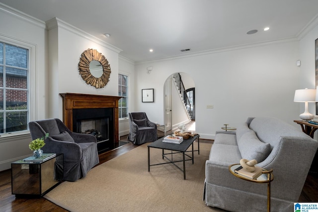 living room with crown molding, a healthy amount of sunlight, and dark wood-type flooring