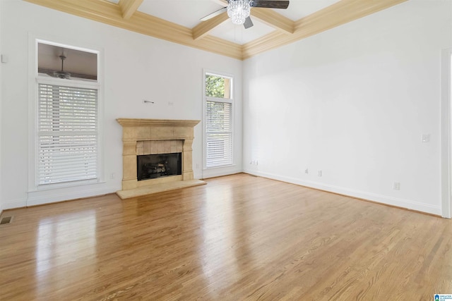 unfurnished living room featuring coffered ceiling, light hardwood / wood-style floors, a premium fireplace, and beamed ceiling