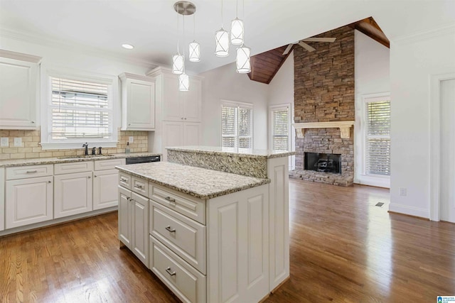 kitchen featuring sink, white cabinetry, hanging light fixtures, a wealth of natural light, and a kitchen island