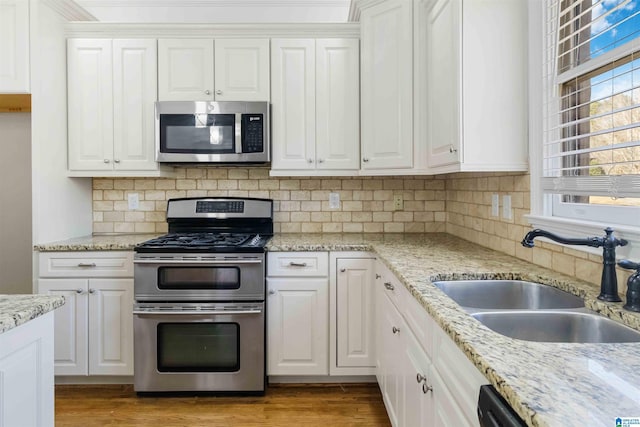 kitchen featuring stainless steel appliances, sink, and white cabinets