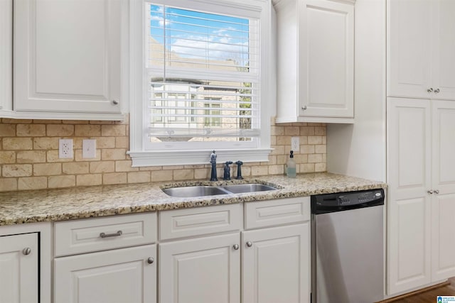 kitchen with sink, white cabinetry, light stone counters, tasteful backsplash, and stainless steel dishwasher