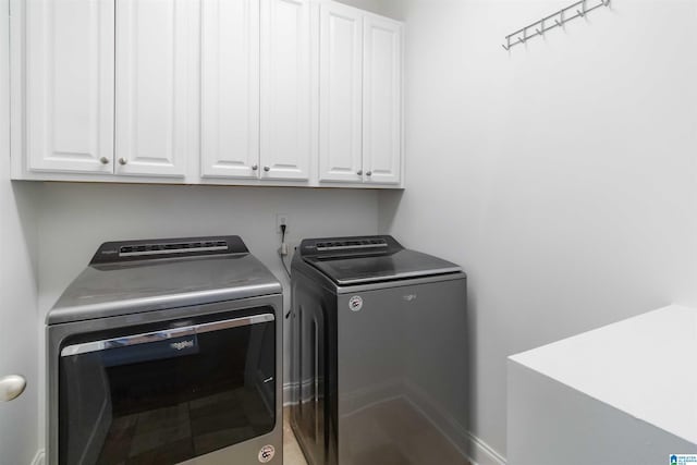 washroom featuring cabinets and washing machine and clothes dryer