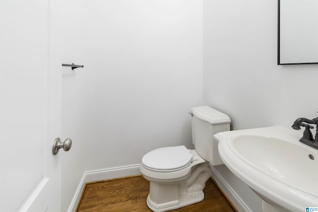 bathroom featuring sink, hardwood / wood-style floors, and toilet