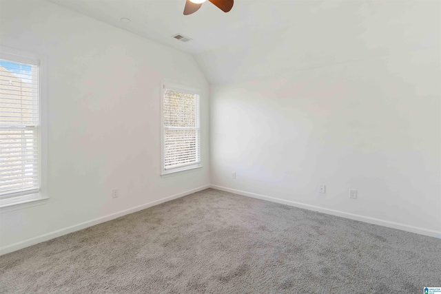 carpeted empty room featuring lofted ceiling, a wealth of natural light, and ceiling fan